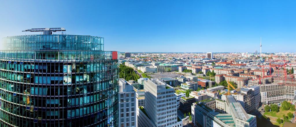 Berliner Skyline hinter einem geschwungenen gläsernen Hochhaus
